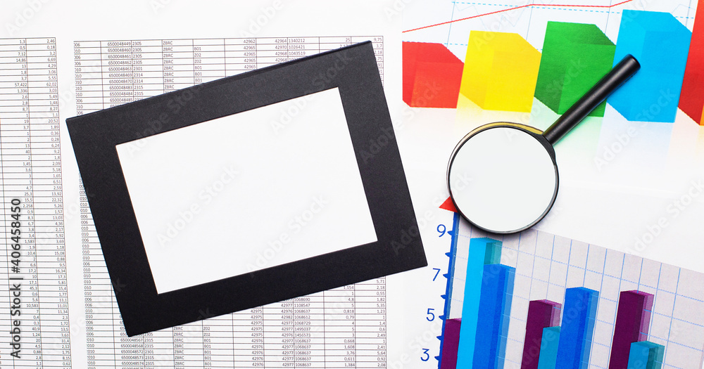 Poster colored charts, reports, magnifying glass and a sheet of paper in a frame on the desktop. top view w