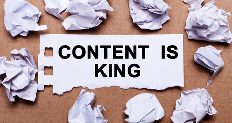 CONTENT IS KING written on white paper on a light brown background.