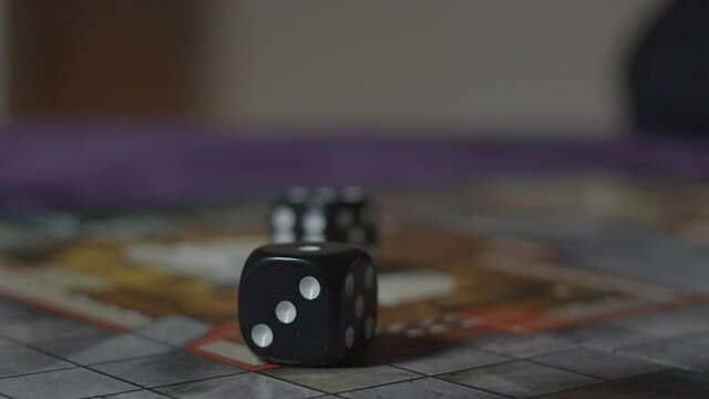 Dice rolling in slow motion into frame - number 3 visible