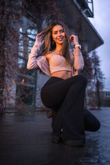 Obraz premium Young pretty Caucasian brunette walking in the city in winter, wearing a pink wool sweater. Street style fashion