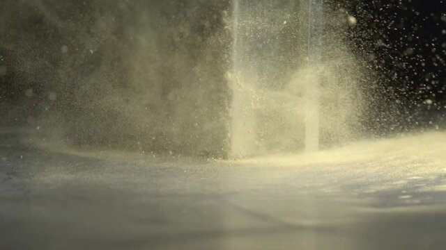 Yellow powder is thrown into a metal piece in slow motion. Yellow powder is thrown into a metal piece