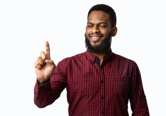 Black Guy Holding Invisible Object On Finger Over White Background