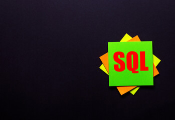 SQL on a bright sticker on a dark background. Copy space