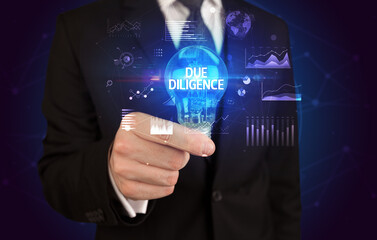 Businessman holding lightbulb with DUE DILIGENCE inscription, Business idea concept