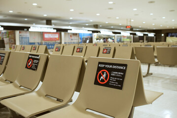 Empty bench seats with social distancing sticker signs during COVID-19 pandemic in Japan　新型コロナウイルス対策で使用禁止のステッカーが貼られたベンチ ソーシャルディスタンス 成田空港