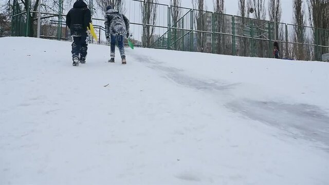 Guys climb the snow slide. Slow motion 01.10.2020 Ukraine, Kiev. HD