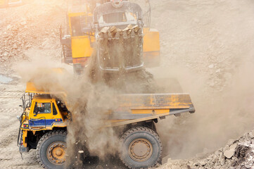 Mining Truck,Open pit mining of iron ore and magnetite ores.Loading the iron ore into heavy dump truck at the opencast mining. © saravut