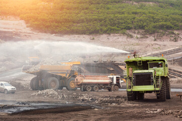 Mining Truck,Heavy truck pours the road with water in the iron ore quarry. Dust removal, protection of the environment. Irrigation of the road from dust © saravut