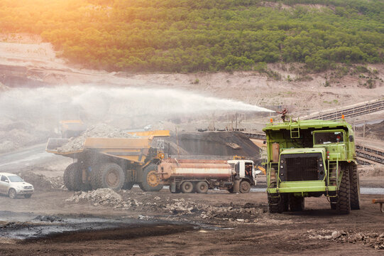 Mining Truck,Heavy truck pours the road with water in the iron ore quarry. Dust removal, protection of the environment. Irrigation of the road from dust