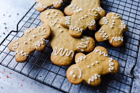 Close up of gingerbread cookies on wire rack on grey stone counter.