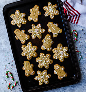 Overhead Of Gingerbread Cookies On Sheet Pan On Grey Stone Counter.