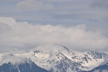 Fototapeta na wymiar Snowy mountains and cloudy sky