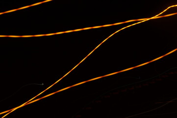 Luminous streamer - neon bright lines on black background.