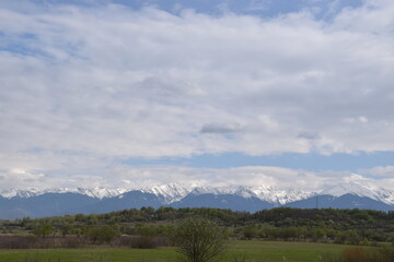 Fototapeta na wymiar Snowy mountains and cloudy skies