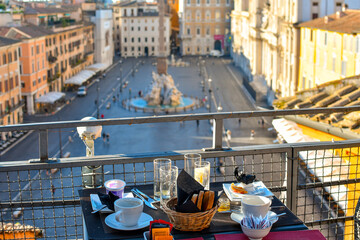 View from a rooftop cafe of table of continental breakfast items with the Piazza Navona, Rome,...