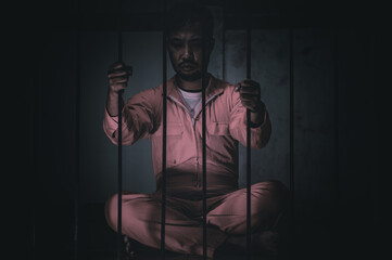 Asian man desperate at the iron prison,prisoner concept,thailand people,Hope to be free,Serious...
