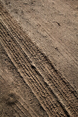 Tyre track on dirt sand or mud, Picture in retro or grunge tone. Car drive on sand. off road track. Track on grass field. Track in farm.