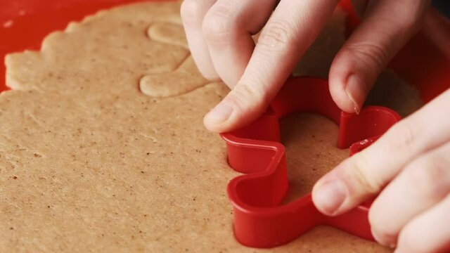Making of gingerbread cookies in the form of gingerbread man, angel, star, bell using plastic mold.