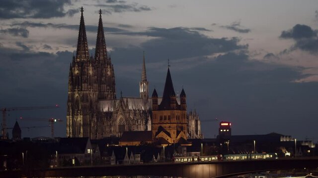 Cologne skyline with cologne cathedral and Gro&szlig; St. Martin. Zoo-Bridge in the foreground with two KVB trains driving on it from the left to right.