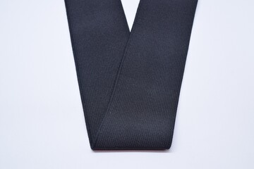 Black Knit Elastic Spool for needlework of the cloth insulated on black background.