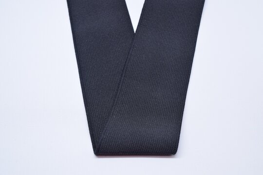 Black Knit Elastic Spool for needlework of the cloth insulated on black background.