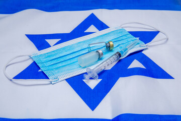 a medical mask, syringe and medicine bottles are on the israeli flag as a symbol of israeli medicine