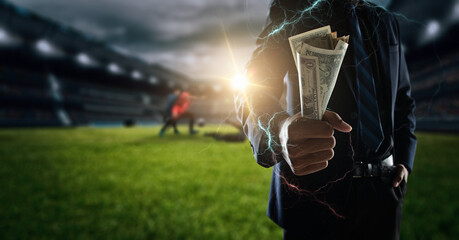 Concept of betting bet sport.businessman holding large amount of bills at Soccer stadium in...