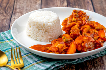 Chicken Afritada (with rice) (Spanish-style Chicken Stew) is a well-known Filipino dish that is cooked in tomato sauce with carrots, potatoes, green peas and bell peppers as the main vegetables.