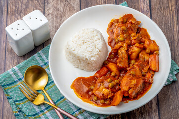 Chicken Afritada (complete top) (Spanish-style Chicken Stew) is a well-known Filipino dish that is cooked in tomato sauce with carrots, potatoes, green peas and bell peppers as the main vegetables.