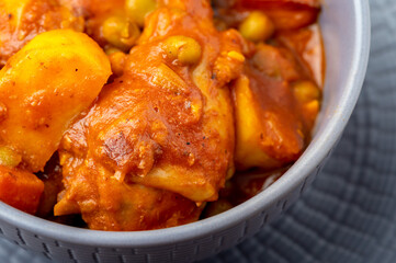 Chicken Afritada ( super close up) (Spanish-style Chicken Stew) is a well-known Filipino dish that is cooked in tomato sauce with carrots, potatoes, green peas and bell peppers as the main vegetables.