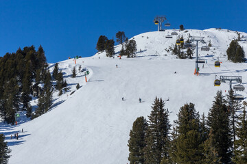 Skiiers and snowboarders enjoying a snow covered mountain