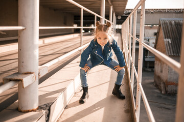 Fototapeta premium Girl in denim clothes dancing hip-hop in the car parking