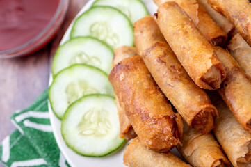 Pork Lumpiang Shanghai (close up with cucumbers on the side) is a Filipino favorite, its a dish usually served at parties and feasts. This is very similar to a spring roll.