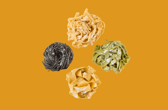 Handmade pasta and spaghetti and tagliatelle noodles on yellow background. Italian cuisine food. 4 types of raw pasta. Online delivery from restaurant. Cooking tagliatelle.