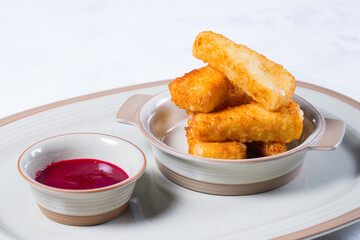 Breaded mozzarella cheese sticks with tomato ketchup.