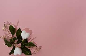 Hearts and green leaves on pink background. Wedding and love concept. Valentines's day aesthetic.