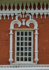 Fototapeta premium a window with a stone white openwork pattern on a red stone wall, an element of the church's decor