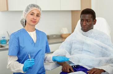 Cosmetician female preparing to aesthetic facial injection with man in medical office