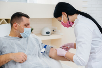 Fototapeta premium A man's blood is taken from a vein for analysis and testing for viruses. The formation of the immune system and antibodies.