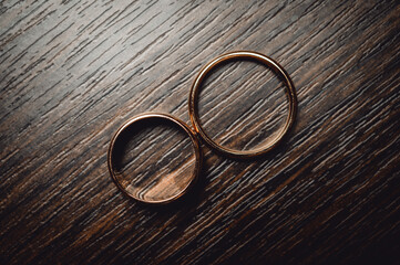 Gold wedding rings on brown wood
