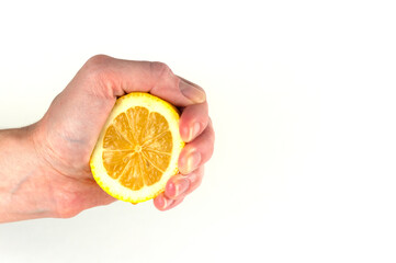 a woman 's hand squeezes a lemon on a white background