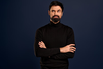 Skeptical, pissed serious-looking male employer in high neck black sweater, cross arms over chest, smirk and look upper left corner at clock impatient, waiting for someone being late