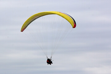 Tandem Paraglider flying wing in a cloudy sky	