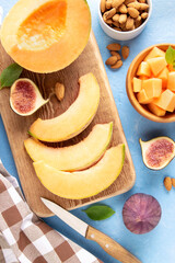 Cantaloupe melon cut into slices on a wooden board.