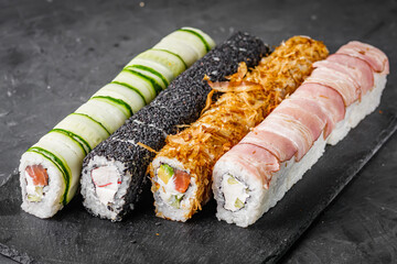 appetizing set of sushi roll on a black stone plate