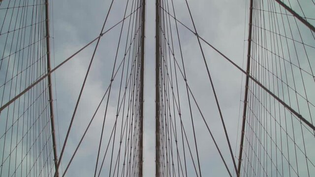 Slow-motion walking on  Brooklyn Bridge looking up perspective cables