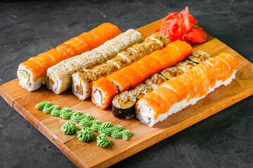 appetizing set of sushi roll on a black stone plate