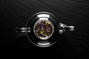 dry tea leaves in a teapot on a stone background, flat lay