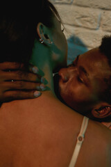 Language of feelings. Young african man kissing woman in neck while relaxing together in the...