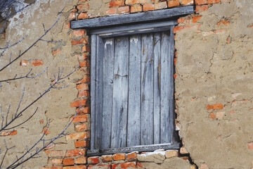 Fototapeta na wymiar A boarded-up window in an old abandoned house